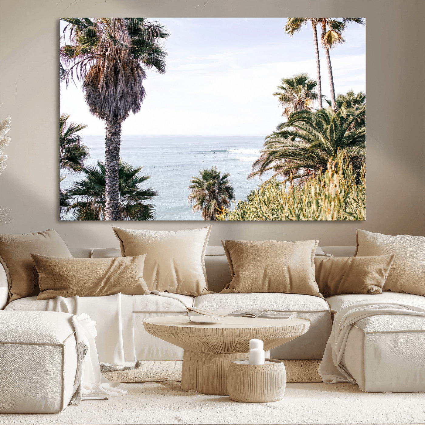 Scenic coastal view with tall palm trees overlooking a calm ocean, soft blue waves, and surfers in the distance, creating a peaceful tropical vibe.