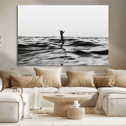Black and white ocean with a hand making a surfer sign among dark waves, creating a dramatic and minimalist seascape with bold contrast.