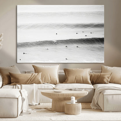 A monochrome photograph of swimmers gliding through gentle ocean waves, evoking a sense of calm and movement.