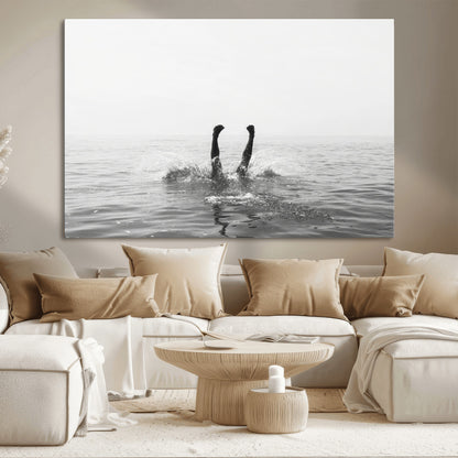 A black and white minimalist water scene capturing a playful splash as a swimmer dives upside down, creating a carefree and artistic aquatic aesthetic.