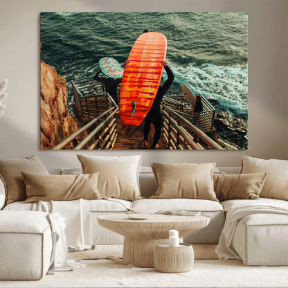 A surfer carrying a bold orange surfboard down a rugged staircase toward the ocean, bathed in golden hour light, capturing the energy of coastal adventure.
