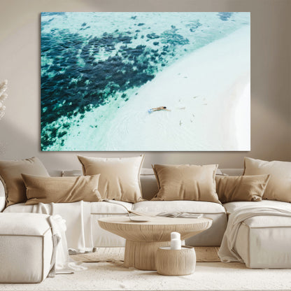 Canvas featuring an aerial view of a swimmer in shallow turquoise waters with coral patterns, ideal for tropical coastal home decor.