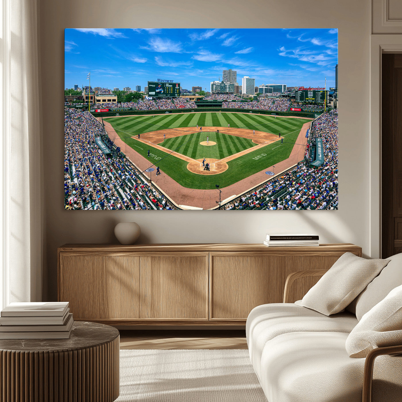 A wide-angle shot of a baseball field filled with spectators, with players on the field and the iconic Wrigley Field scoreboard in the background.