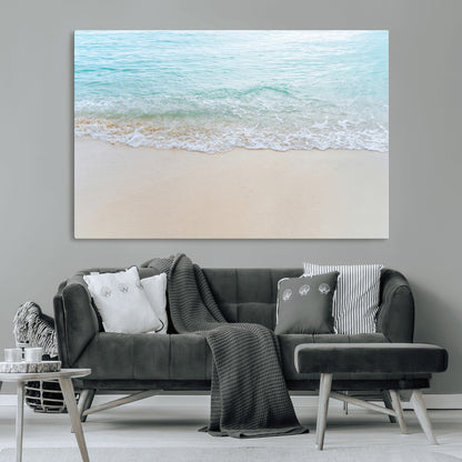 Soft shoreline with gentle aqua waves on smooth sand, ideal for minimalist coastal or pastel ocean-inspired home wall decor.