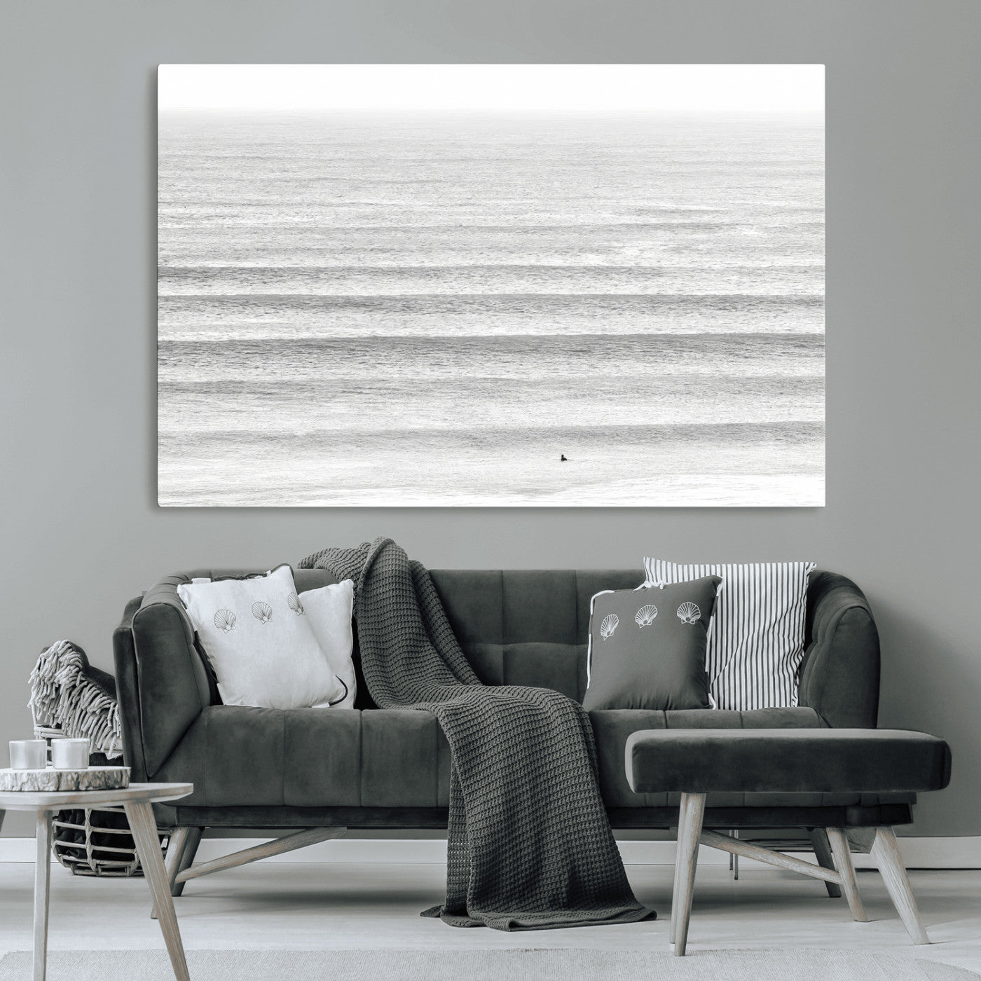 Monochrome photo of a lone surfer in calm layered waves, perfect for minimalist coastal or moody ocean-inspired wall decoration.