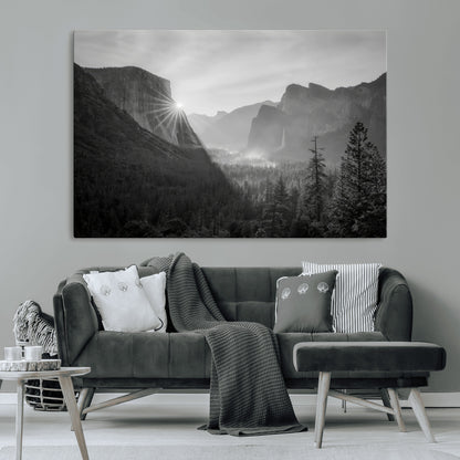 Black and white landscape of Yosemite with sun rays peeking over El Capitan, ideal for moody nature or modern rustic decor.