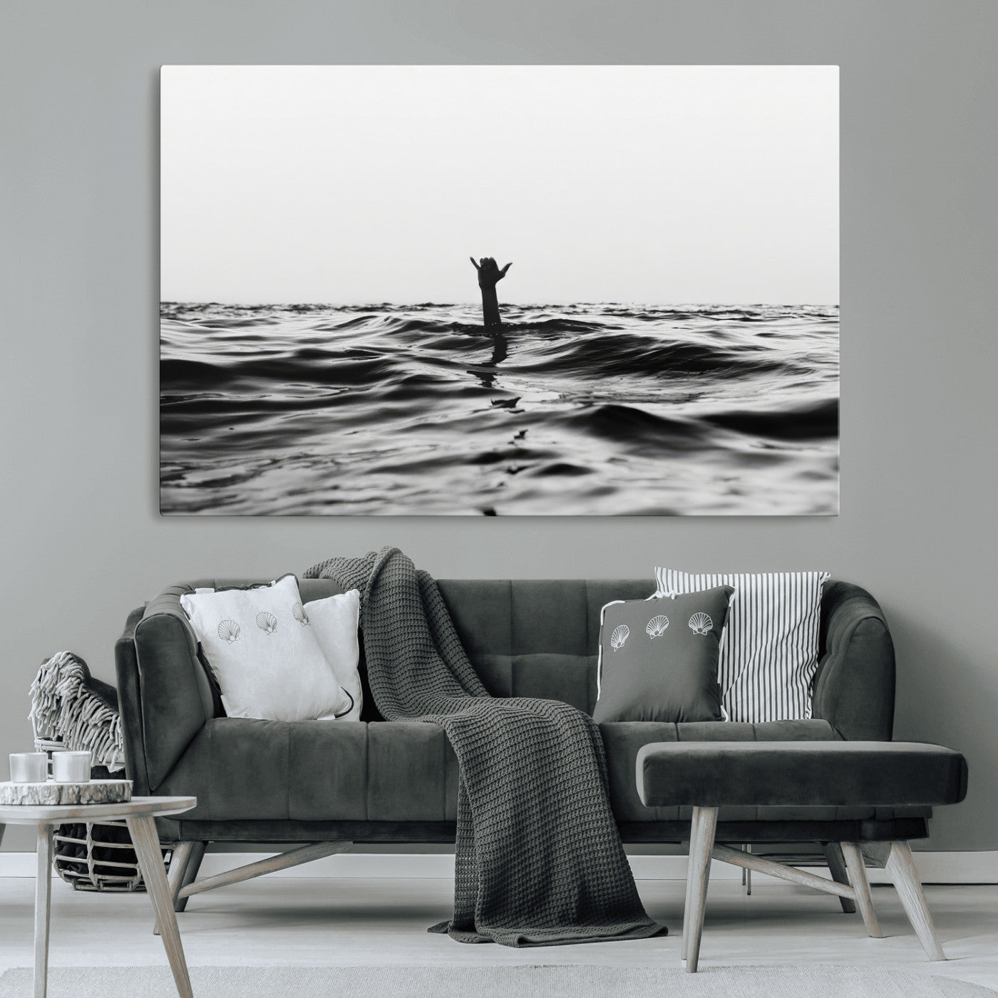 Black and white ocean with a hand making a surfer sign among dark waves, creating a dramatic and minimalist seascape with bold contrast.