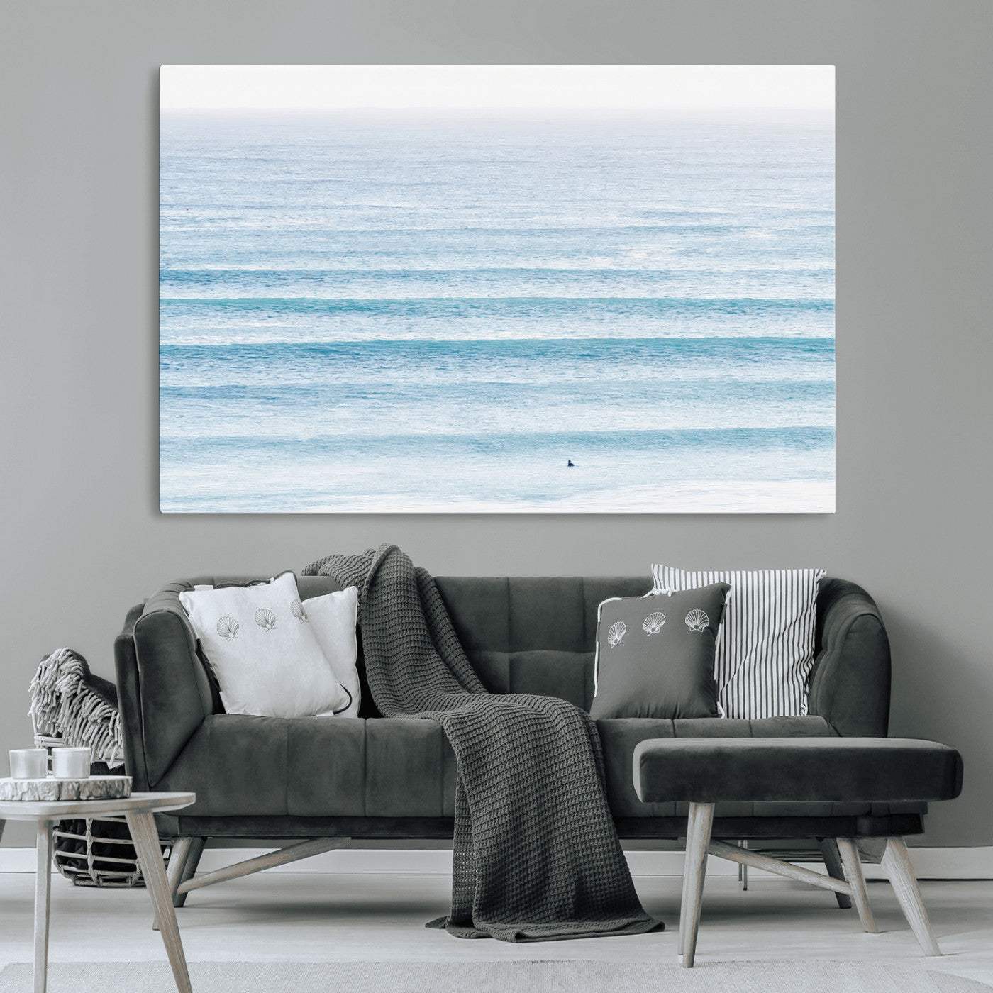 Minimalist ocean view with soft blue waves and a lone surfer, creating a serene and airy coastal aesthetic, perfect for tranquil home decor.