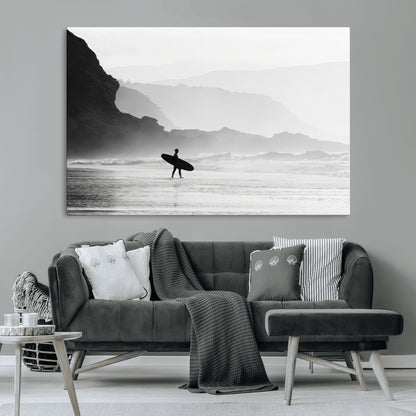 A lone surfer walking along a misty beach with cliffs in the background, carrying their board, capturing a serene and minimal ocean moment.