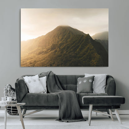 Sunlit mountain peak with mist rolling over its rugged slopes, bathed in golden light, creating a warm and tranquil nature-inspired scene.
