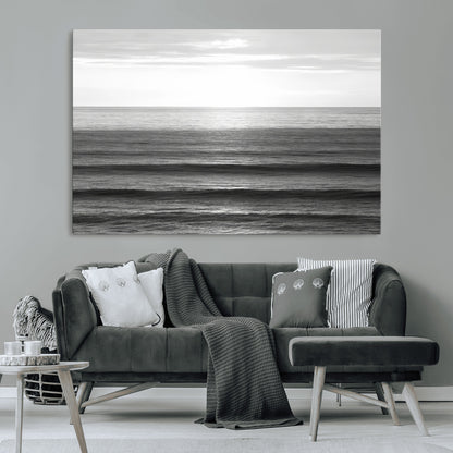 Minimalist black and white ocean view with layered waves reflecting sunlight, evoking a sense of calm and coastal serenity.