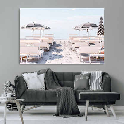 A serene minimalist beach scene featuring striped umbrellas, soft pastel sand, and an elegant lounge setup, creating a tranquil and stylish coastal retreat.