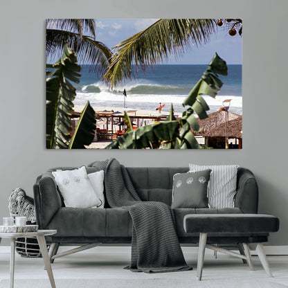 Canvas wall art of a tropical surf scene framed by palm trees, with a surfer on the shore and waves rolling in, ideal for beach-themed decor.