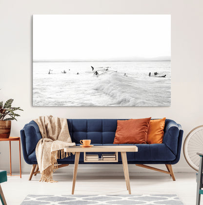 Monochrome photo of surfers riding and waiting on ocean waves, ideal for surf-themed or coastal energy wall decor.