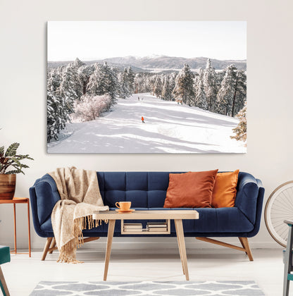 Bright ski trail lined with snow-covered pines and a skier in orange, perfect for alpine adventure or winter sports-inspired decor.