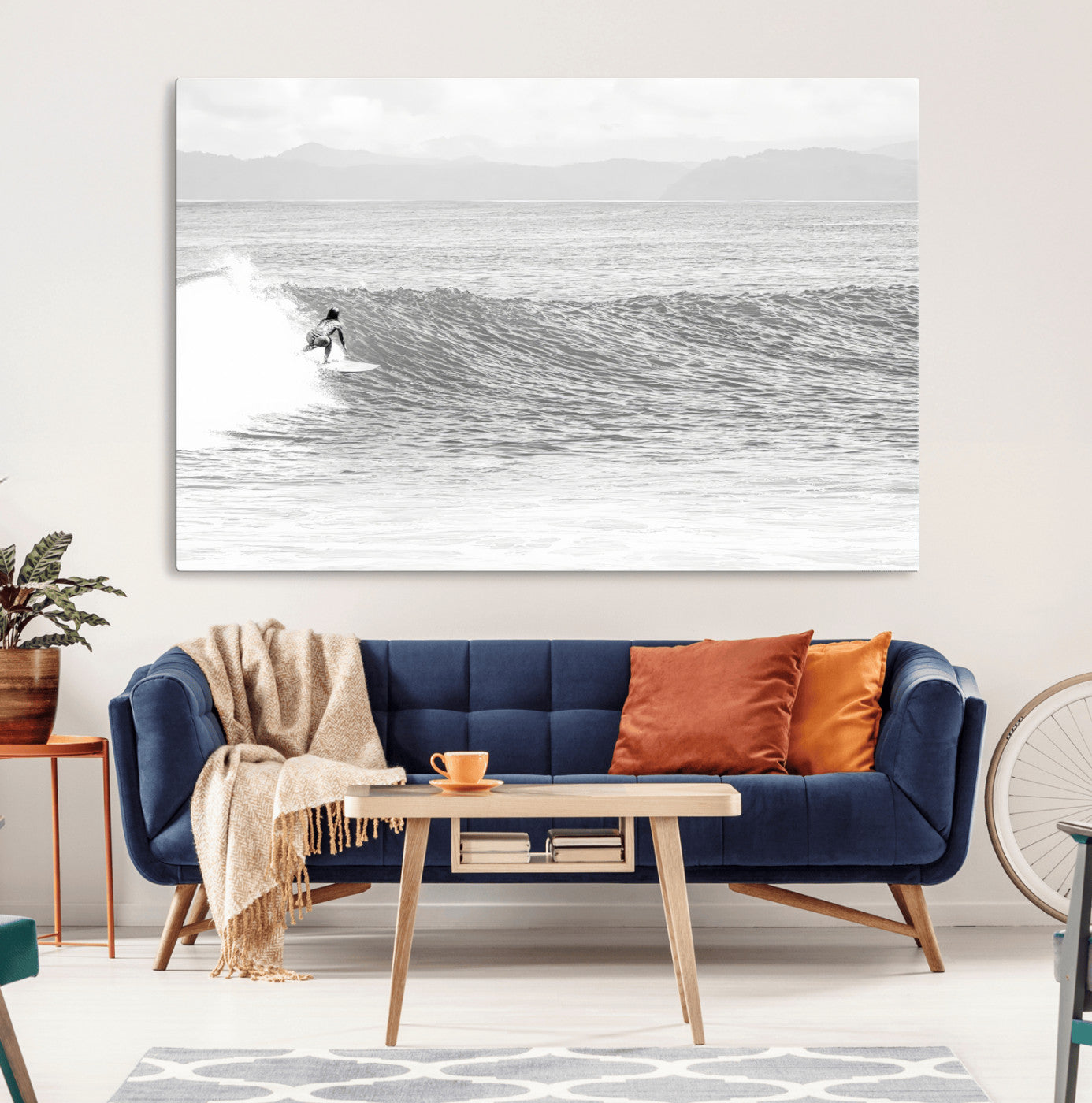 Monochrome photo of a surfer riding a wave with distant mountains, ideal for coastal motion or black and white surf-themed wall decor.