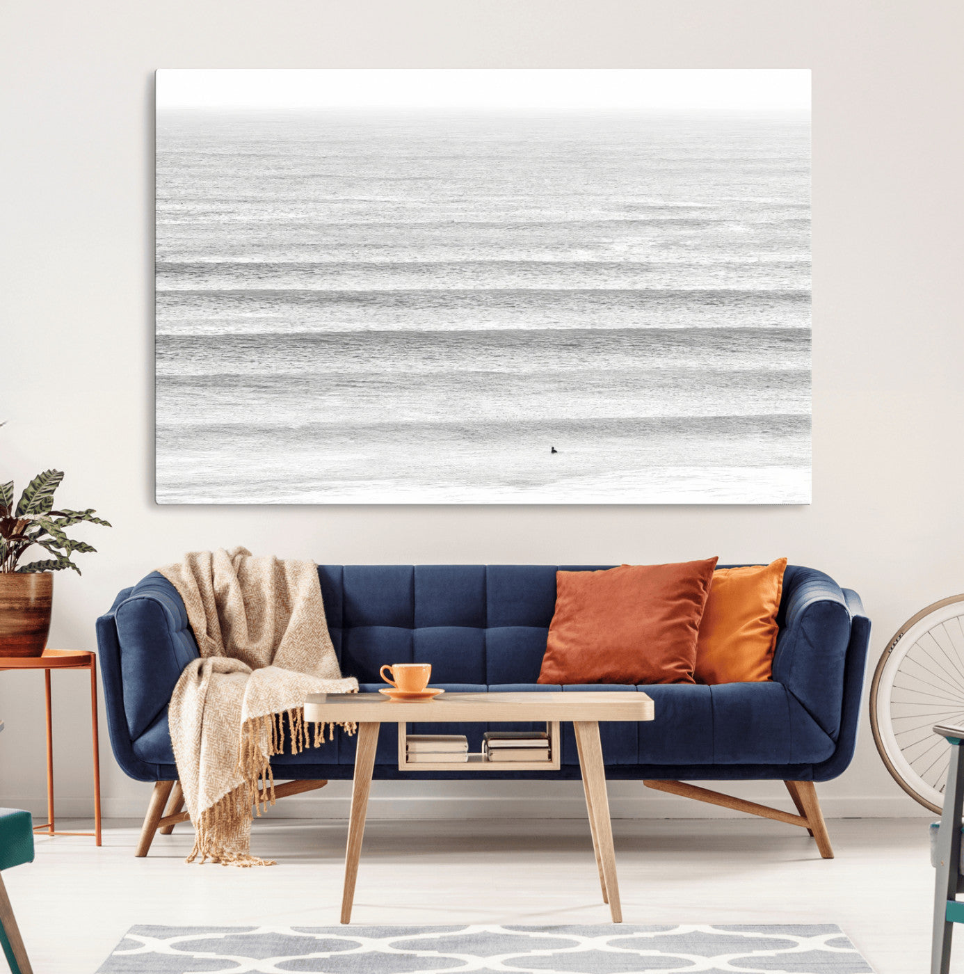 Monochrome photo of a lone surfer in calm layered waves, perfect for minimalist coastal or moody ocean-inspired wall decoration.