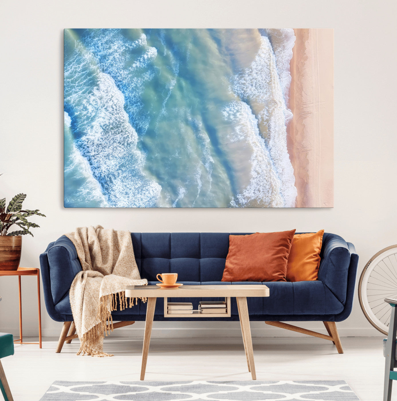 Aerial photo of soft blue waves meeting sandy shore, perfect for modern coastal or beach-themed decor with a light and tranquil aesthetic.
