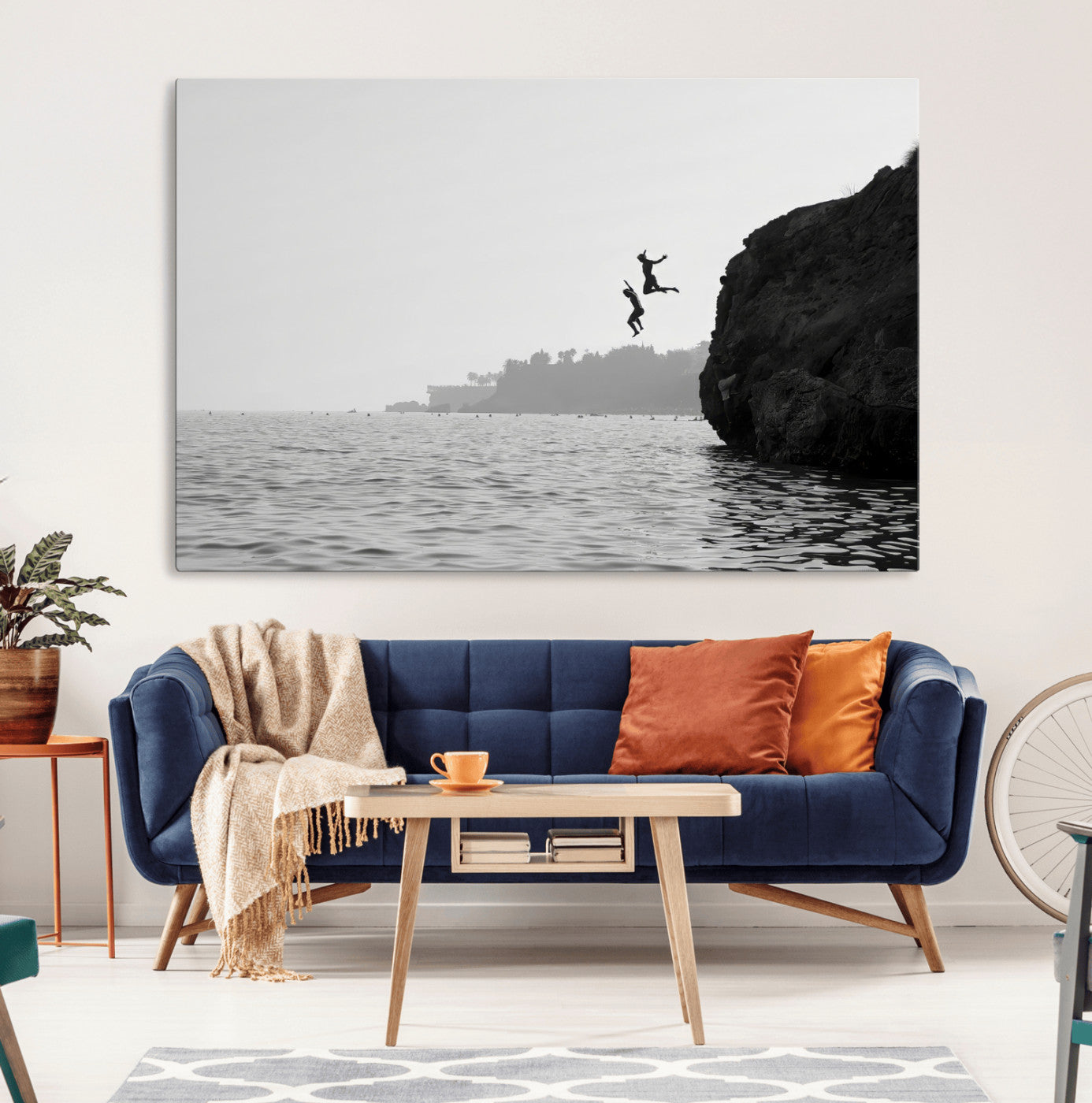 Black and white canvas of two figures cliff jumping into the sea, captured with moody tones, ideal for modern coastal or adventure-themed home decor.   2/2