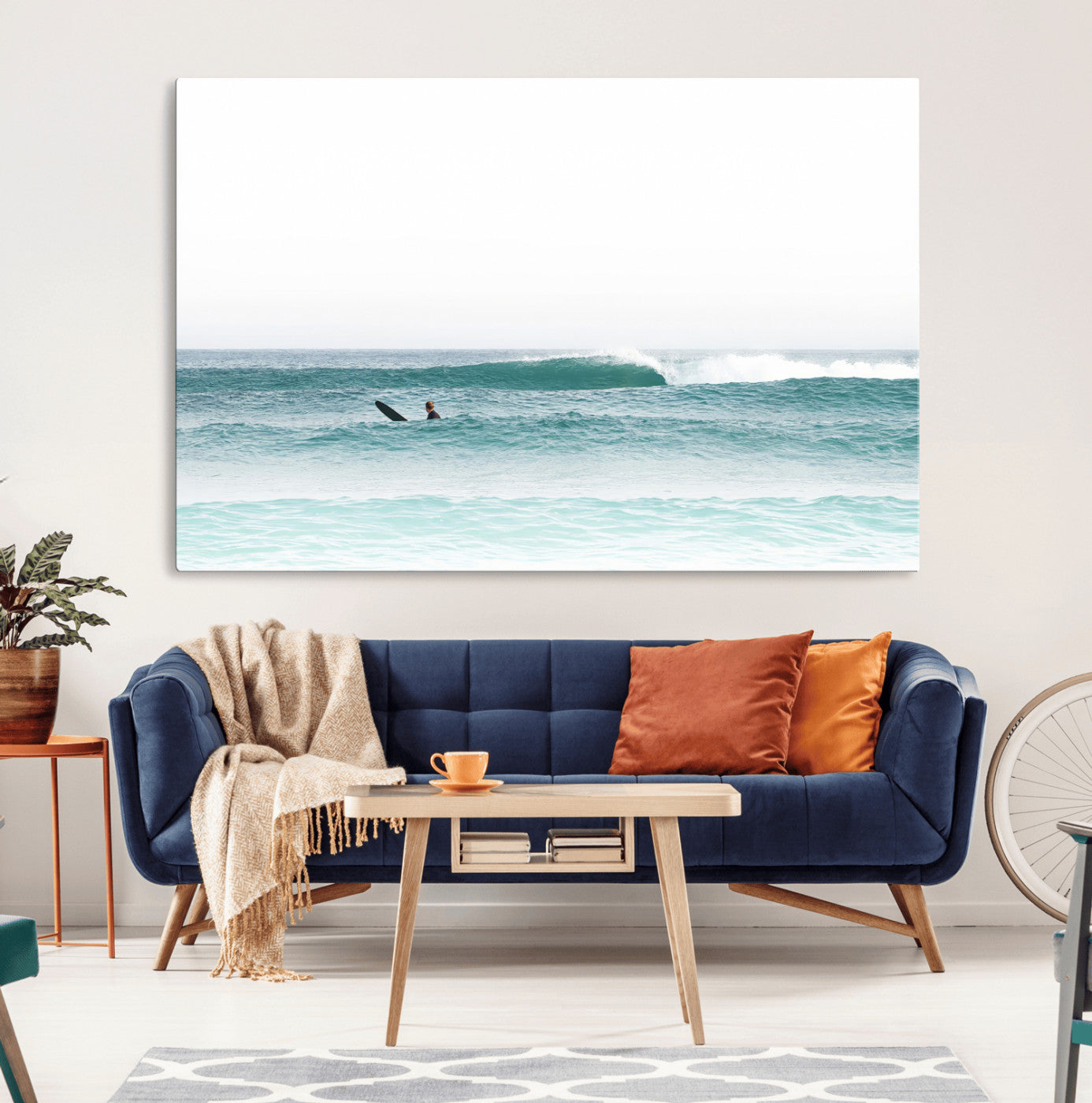 Minimalist photo of a lone surfer on calm aqua waves under bright sky, perfect for Scandinavian coastal or serene ocean-inspired home decor.