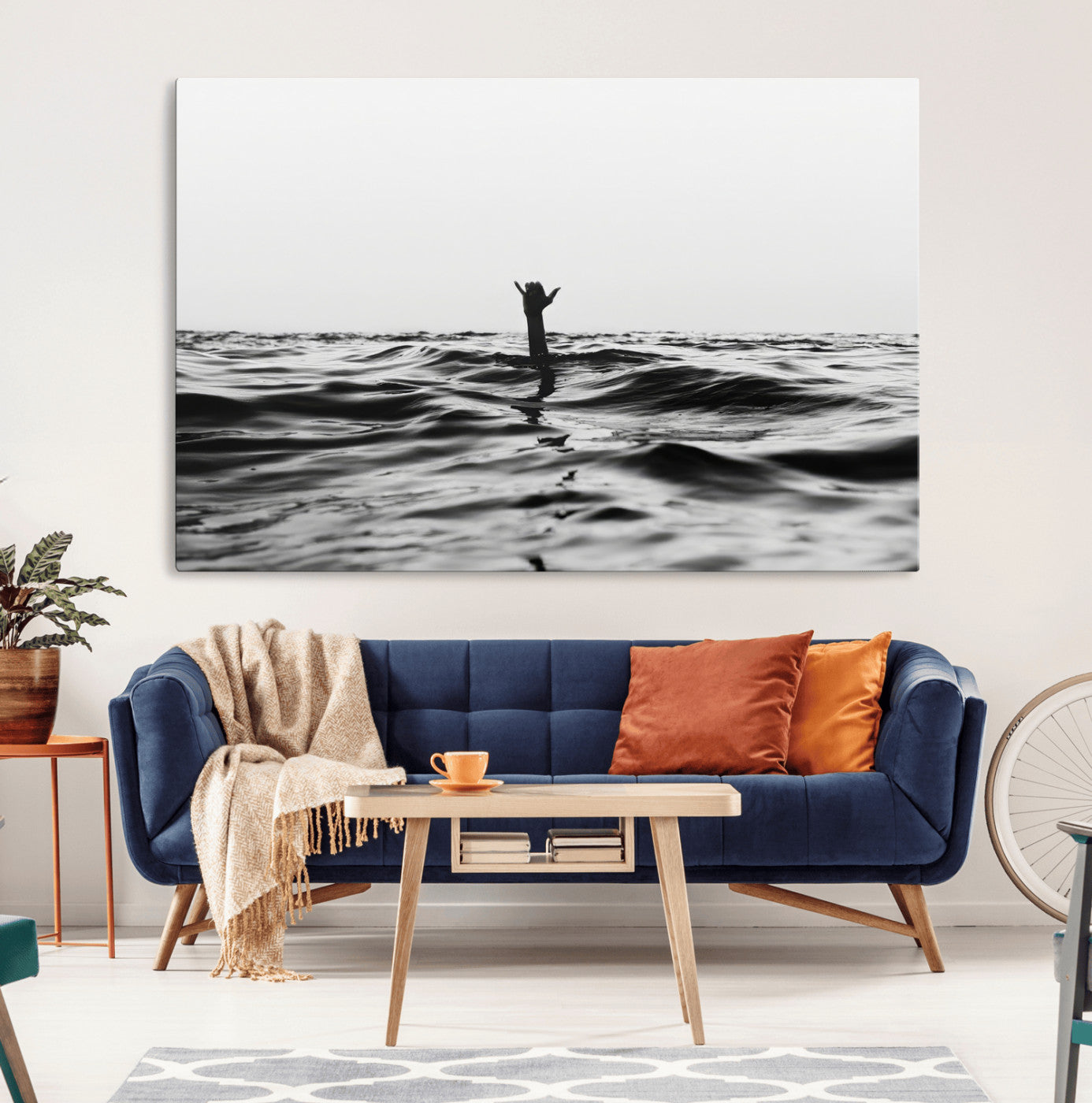 Black and white ocean with a hand making a surfer sign among dark waves, creating a dramatic and minimalist seascape with bold contrast.