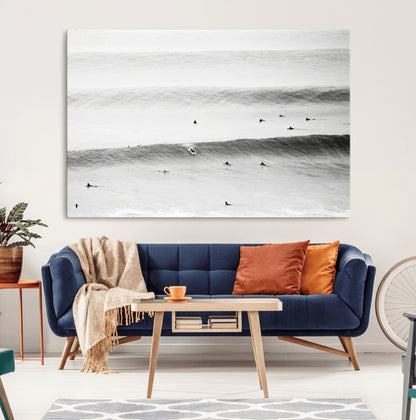 A monochrome photograph of swimmers gliding through gentle ocean waves, evoking a sense of calm and movement.