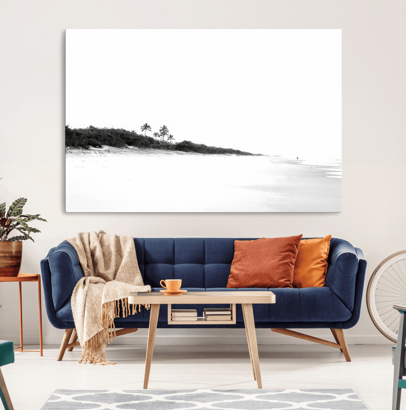 A black and white minimalist coastal scene with a vast open beach, distant palm trees, and a lone figure walking along the shoreline, evoking serenity and solitude.