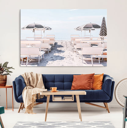 A serene minimalist beach scene featuring striped umbrellas, soft pastel sand, and an elegant lounge setup, creating a tranquil and stylish coastal retreat.