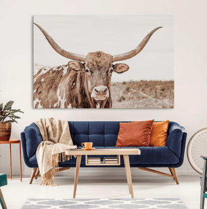 A longhorn cow in soft beige desert tones, standing calmly in open land, perfect for neutral western or rustic farmhouse interiors.