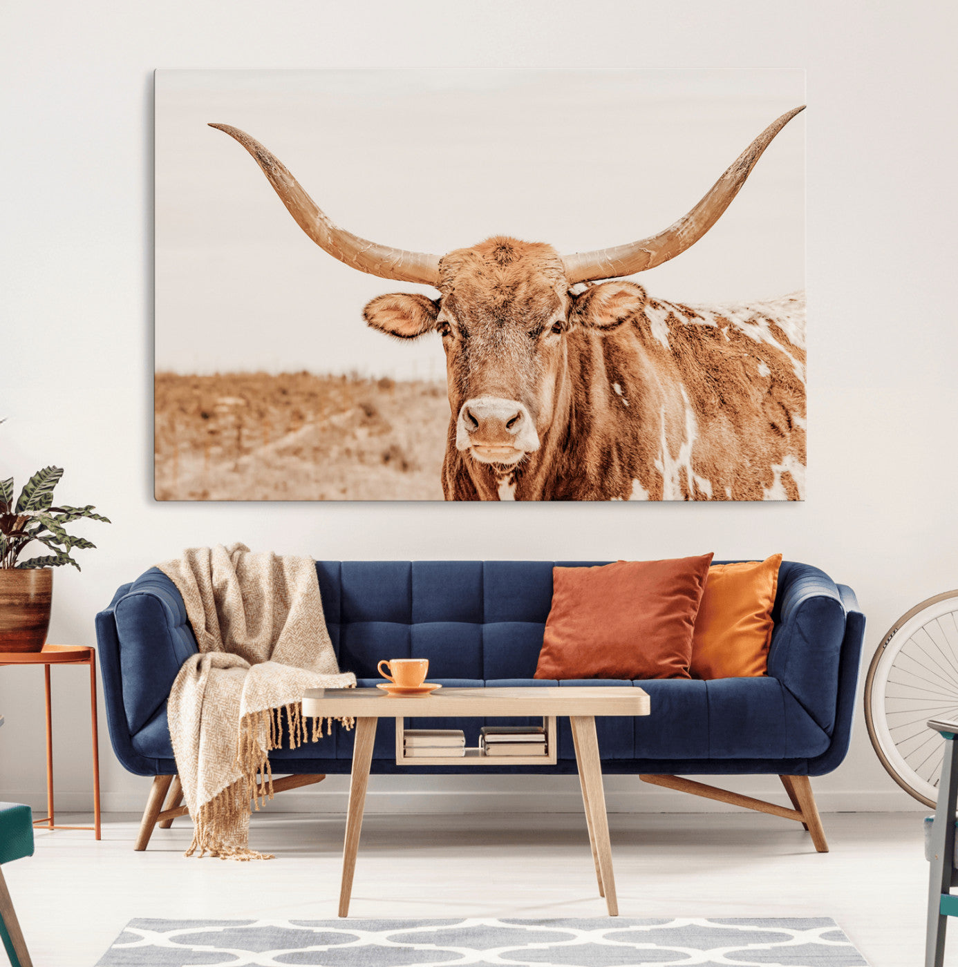 A longhorn bull standing proudly in a sunlit desert field with warm neutral tones, ideal for rustic western or farmhouse interiors.