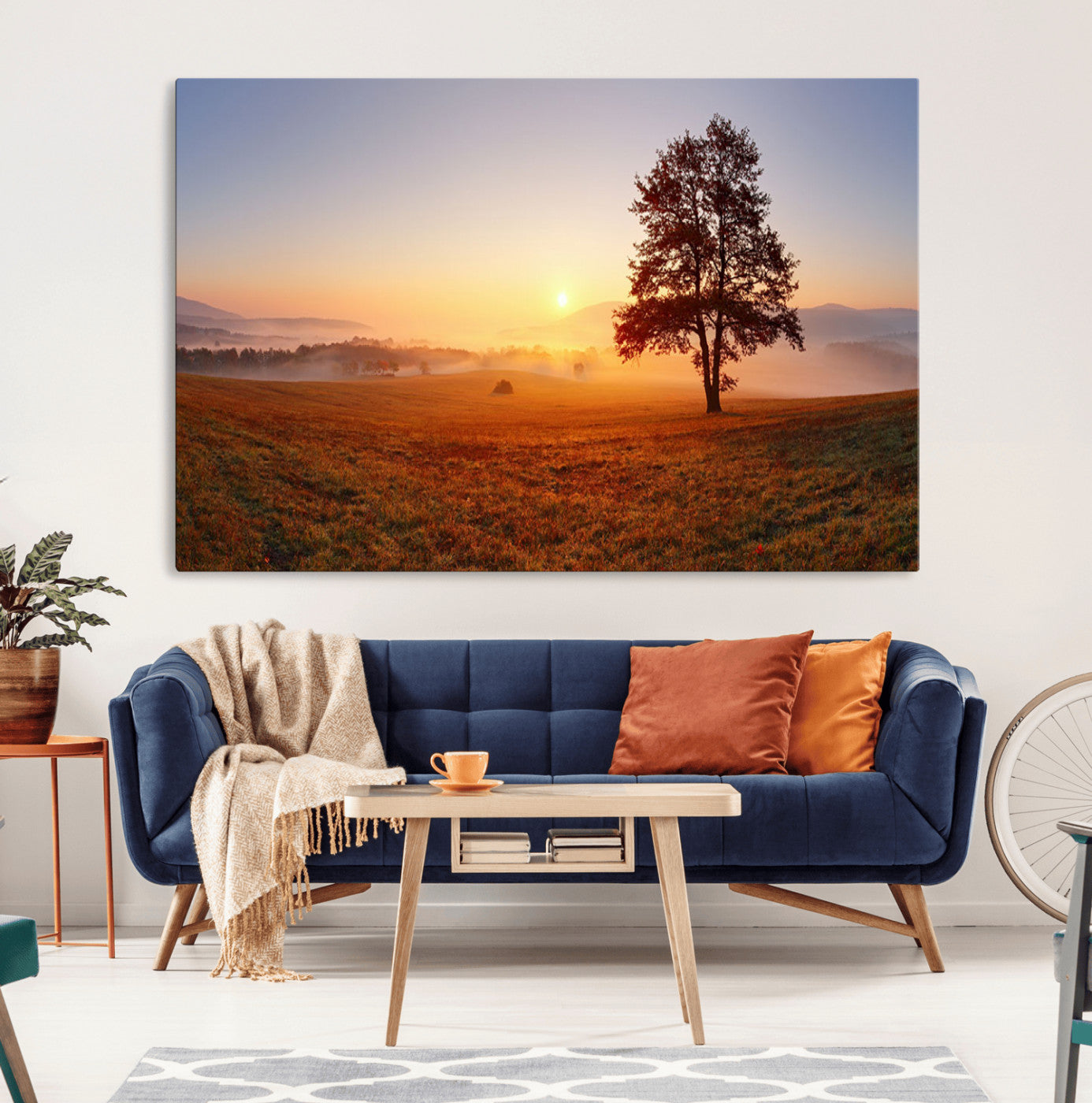 A tranquil landscape at sunrise with a mist-covered field and a lone tree, creating a peaceful and natural atmosphere.
