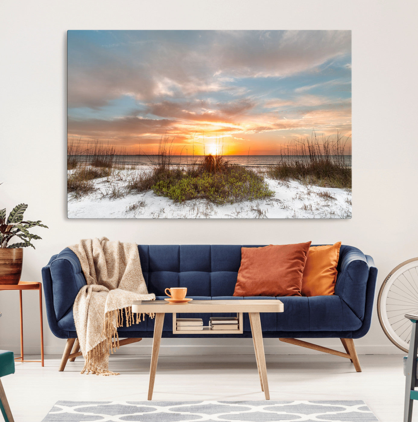 A tranquil beach scene featuring golden sunset hues over the water, with grasses in the foreground and a peaceful, serene atmosphere.