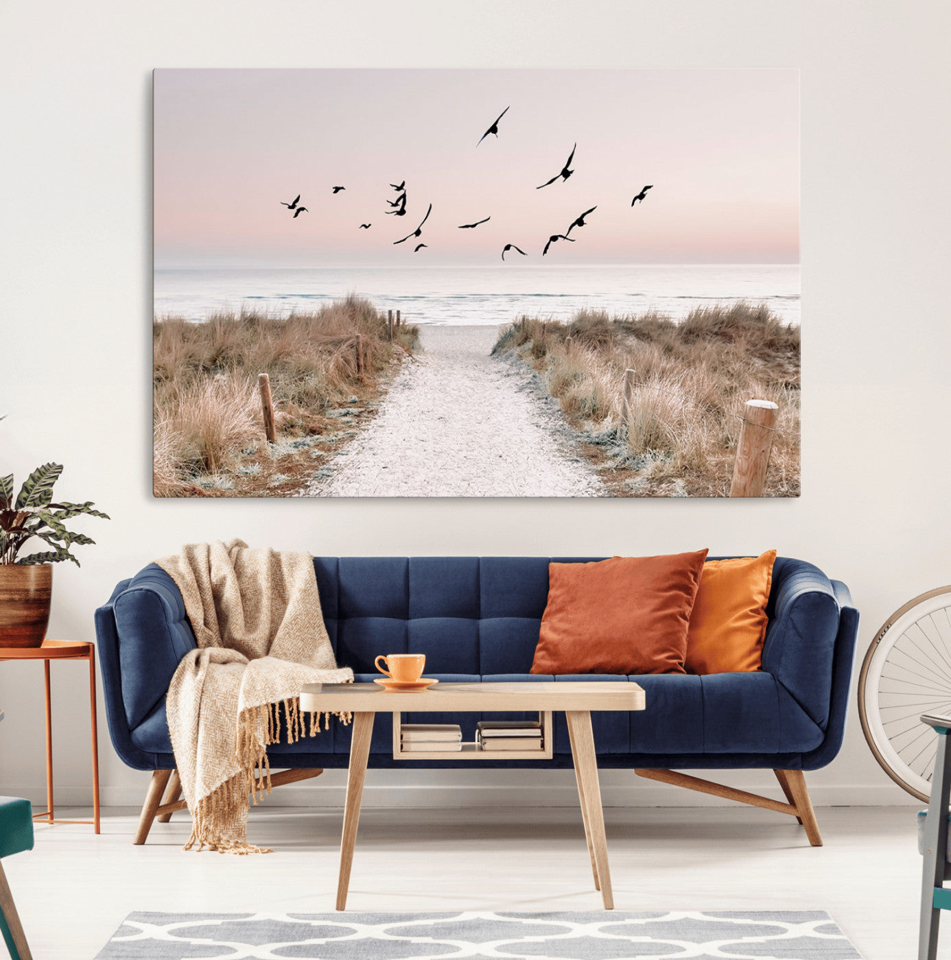 A peaceful coastal pathway leading to the ocean, with birds flying across a soft pastel sky, creating a calm and scenic beach atmosphere.