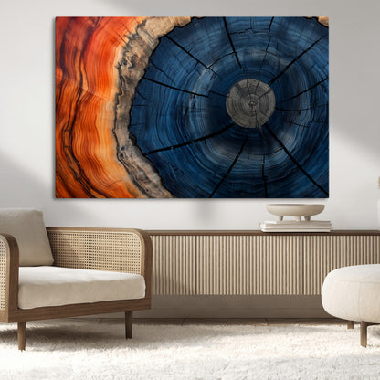 A captivating close-up of a tree trunk, showcasing its concentric rings in rich shades of blue, orange, and brown, highlighting the organic patterns of natural wood.