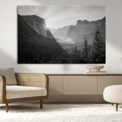 Black and white landscape of Yosemite with sun rays peeking over El Capitan, ideal for moody nature or modern rustic decor.