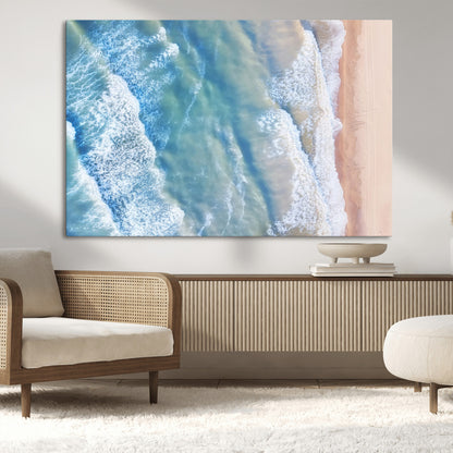 Aerial photo of soft blue waves meeting sandy shore, perfect for modern coastal or beach-themed decor with a light and tranquil aesthetic.