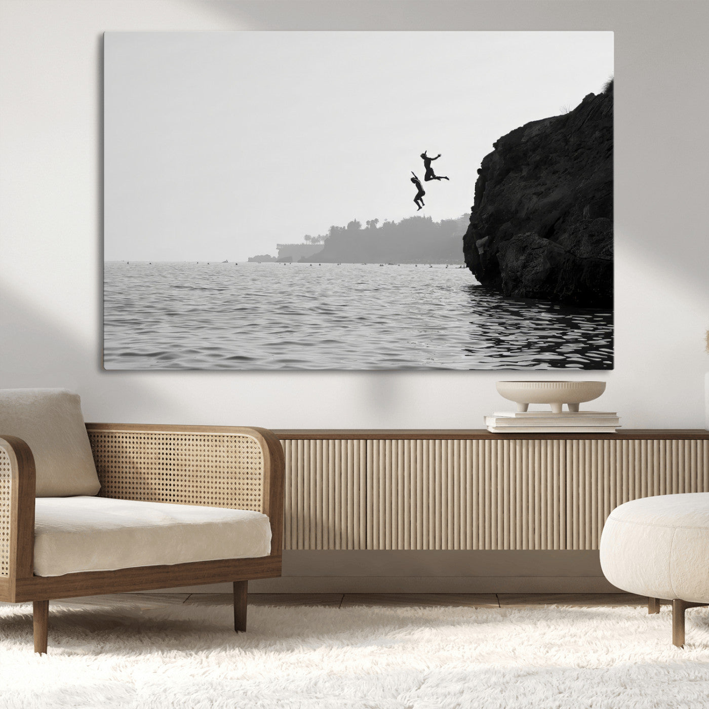 Black and white canvas of two figures cliff jumping into the sea, captured with moody tones, ideal for modern coastal or adventure-themed home decor.   2/2