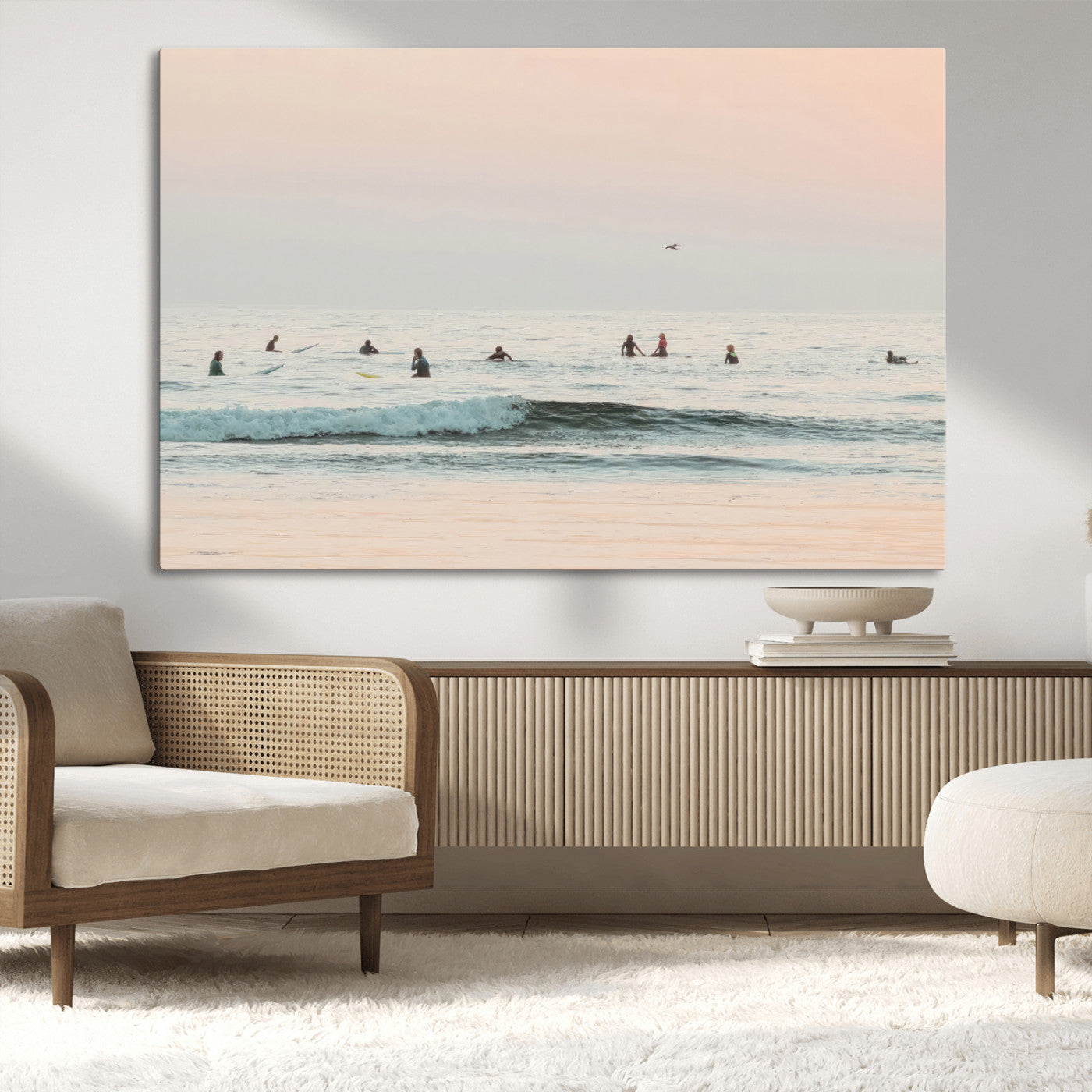 Dreamy photo of surfers waiting on soft pastel waves under a pink sunset sky, ideal for soft coastal minimalist or serene ocean-themed home decor.