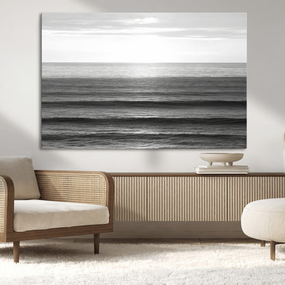 Minimalist black and white ocean view with layered waves reflecting sunlight, evoking a sense of calm and coastal serenity.