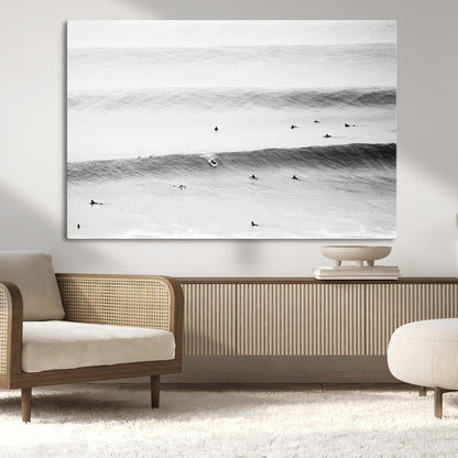 A monochrome photograph of swimmers gliding through gentle ocean waves, evoking a sense of calm and movement.