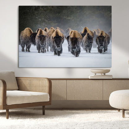 A herd of American bisons walking through deep snow in a forest, evoking a powerful rustic wilderness mood for western-style interiors.