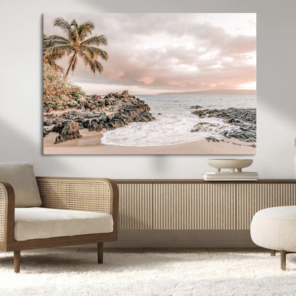 A peaceful beach scene with a palm tree and rocks, soft waves washing onto the shore under a soft pastel sky at sunset.