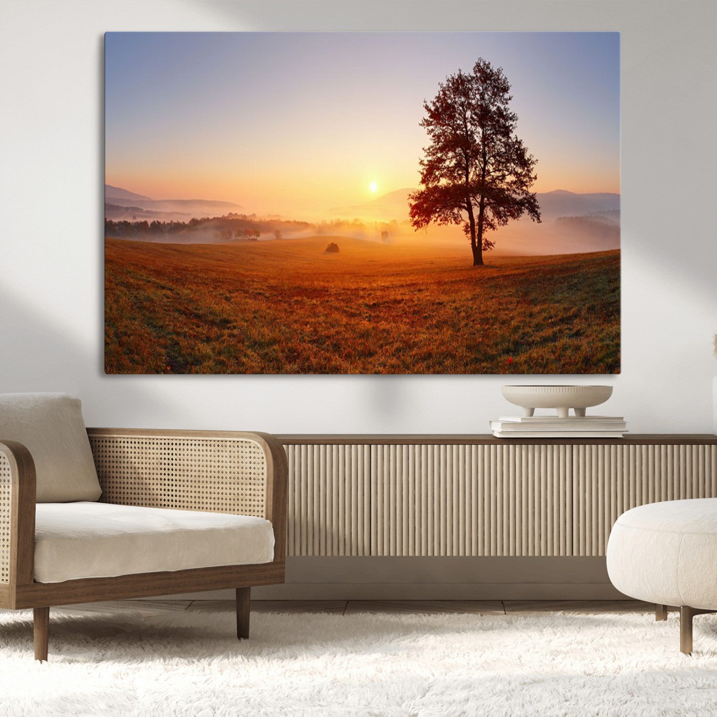 A tranquil landscape at sunrise with a mist-covered field and a lone tree, creating a peaceful and natural atmosphere.