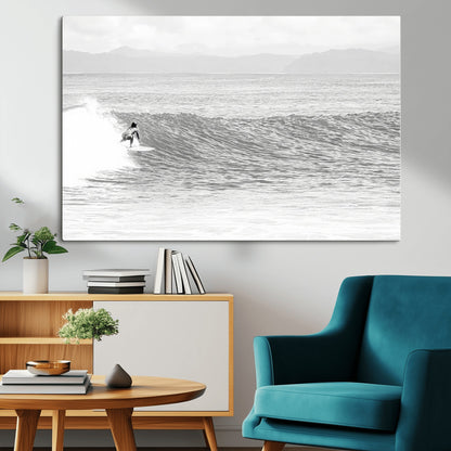 Monochrome photo of a surfer riding a wave with distant mountains, ideal for coastal motion or black and white surf-themed wall decor.