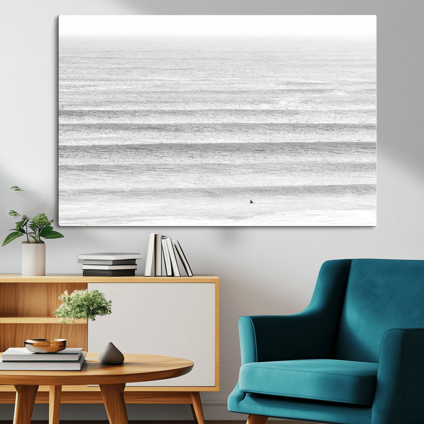 Monochrome photo of a lone surfer in calm layered waves, perfect for minimalist coastal or moody ocean-inspired wall decoration.