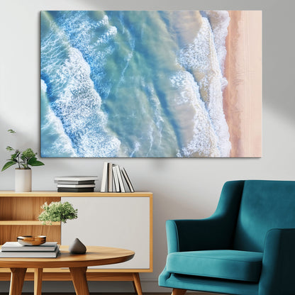Aerial photo of soft blue waves meeting sandy shore, perfect for modern coastal or beach-themed decor with a light and tranquil aesthetic.
