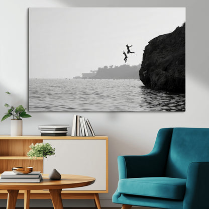 Black and white canvas of two figures cliff jumping into the sea, captured with moody tones, ideal for modern coastal or adventure-themed home decor.   2/2