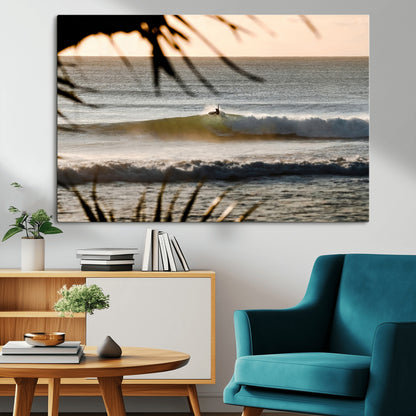 Photo of a surfer riding a golden hour wave at sunset, with tropical tones and dreamy light, perfect for tropical boho or coastal home decor.