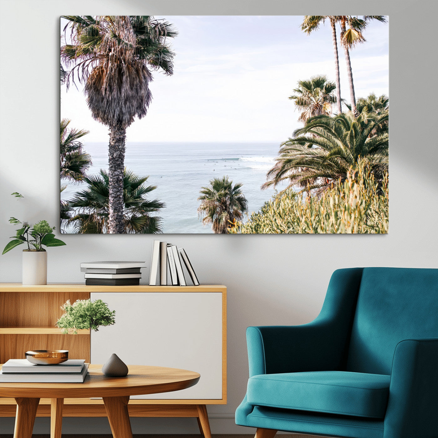 Scenic coastal view with tall palm trees overlooking a calm ocean, soft blue waves, and surfers in the distance, creating a peaceful tropical vibe.