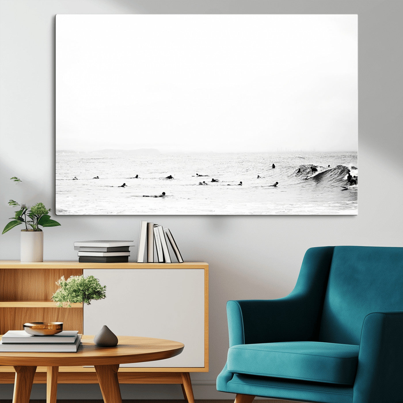 A group of surfers floating in the ocean, waiting for waves under a vast, moody sky, captured in black and white.